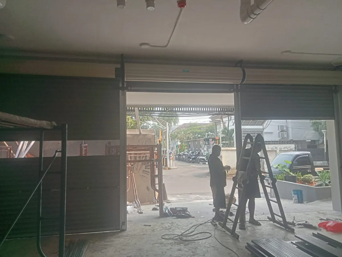 Teknisi menyetel per as gulung rolling door
