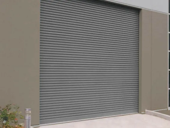 Rolling door industri abu-abu di bangunan gudang